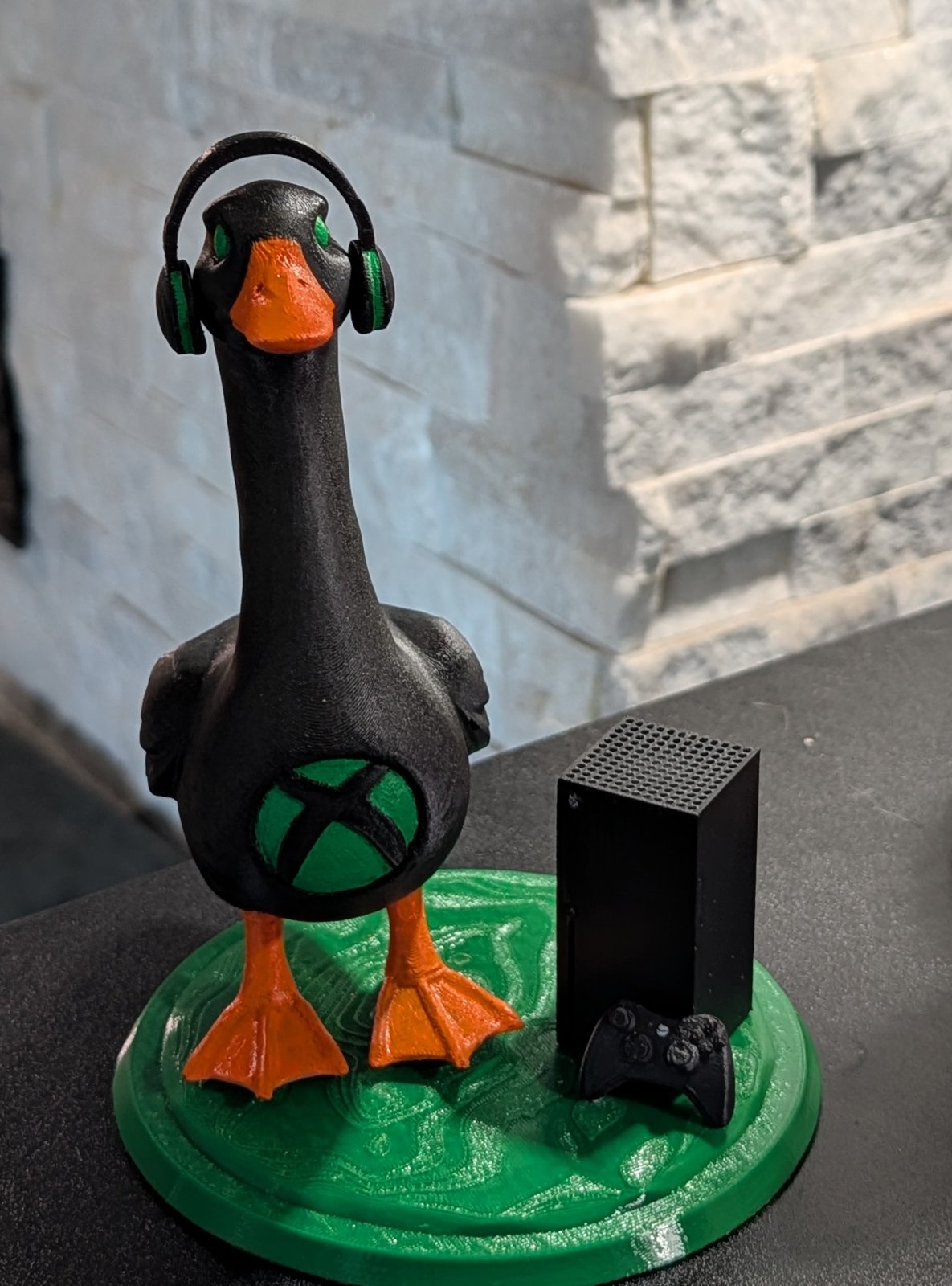 Honkster Chief, a black 3D-printed goose with a green XBOX logo and headphones, next to an XBOX Series X