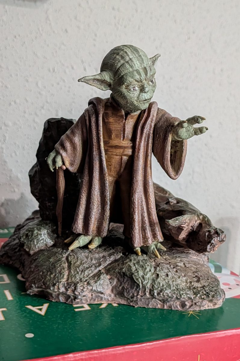 A hand-painted 3D-printed Yoda in painted robes, standing on a rocky Dagobah-style base with his cane