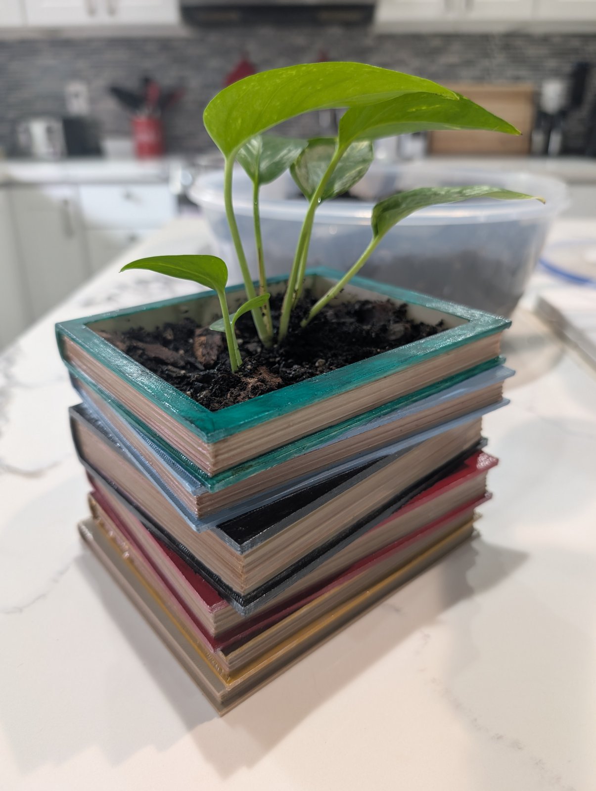 The same painted book-stack planter seen from a lower angle